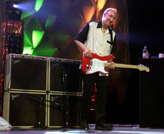 Ca. 2000, in front of dual Fender Vibro-King combos and extension cabs. Guitar is Fender Eric Clapton model Stratocaster.