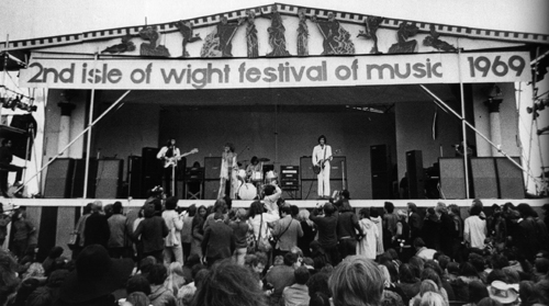 August 1969, the 2nd Annual Isle of Wight festival, which featured The Who’s 2,500-watt WEM PA system. Visible are three Marshall 8x10 PA cabinets per stage side, and WEM columns and cabs set up in the backline as foldback.
