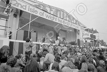 August 1969, the 2nd Annual Isle of Wight festival, which featured The Who’s 2,500-watt WEM PA system. A wider shot of the Who’s PA setup at the festival (though with Richie Havens performing). Three of The Who’s Marshall 8x10 cabs are visible at stage-right, and a stack of WEM slaves or PA amps are visible at far left. © repfoto.com.