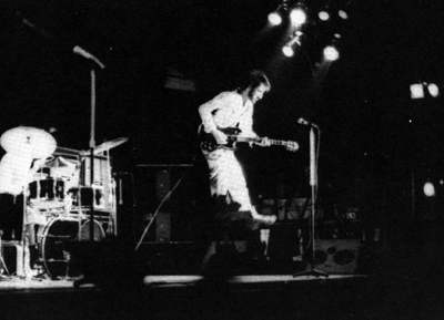 Ca. December 1971, closeup view of stage, with floor wedge visible at stage right. Sunn monitor stack at rear of stage next to Pete’s Hiwatt rig.