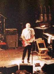 Ca. 1999, playing through Hiwatt DR103W half-stack. Note three Gibson SJ-200 acoustics backstage.