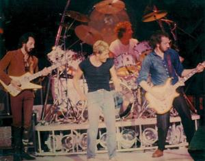 Click to view larger version. Ca. 1979, performing Trick of the Light, with John on 8-string Alembic Explorer and Pete playing 4-string Alembic Series I.