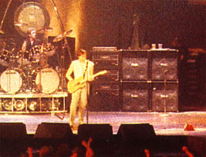 1982: Pete’s rig with four MESA/Boogie 4×12 cabinets. Amplifiers are three Hiwatt CP103s, topped with Roland SDE-2000 DDL digital delay rack unit. Guitar is gold-top Schecter.
